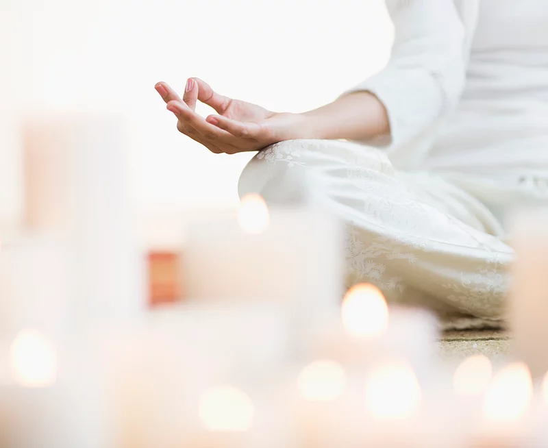 Person meditating with candles