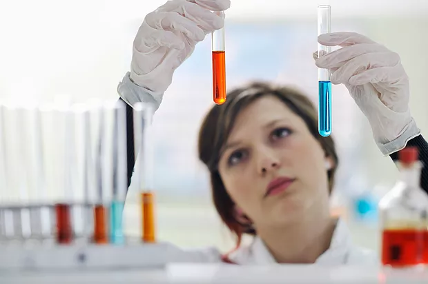 Woman in lab looking at test tubes