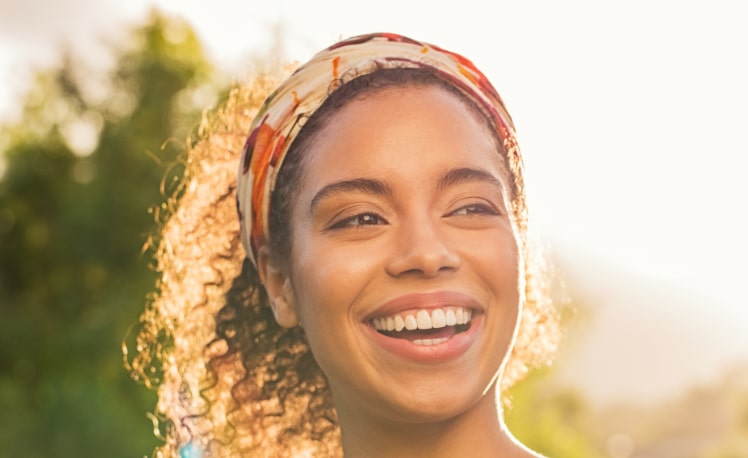 Young african woman smiling at sunset